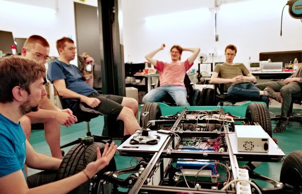 Team gathered around a prototype vehicle